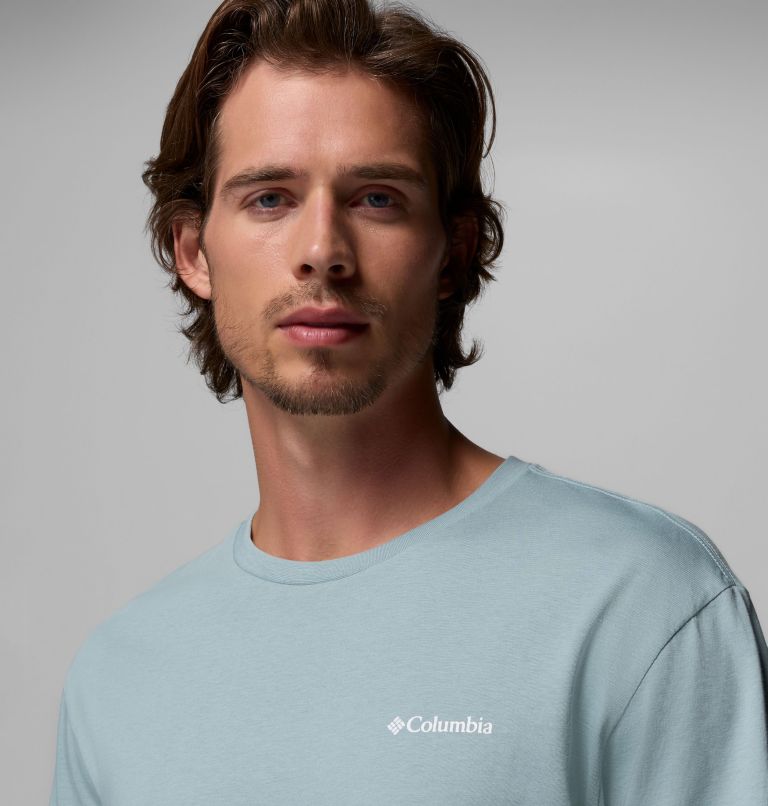 Man wearing a light blue Columbia shirt against a gray background