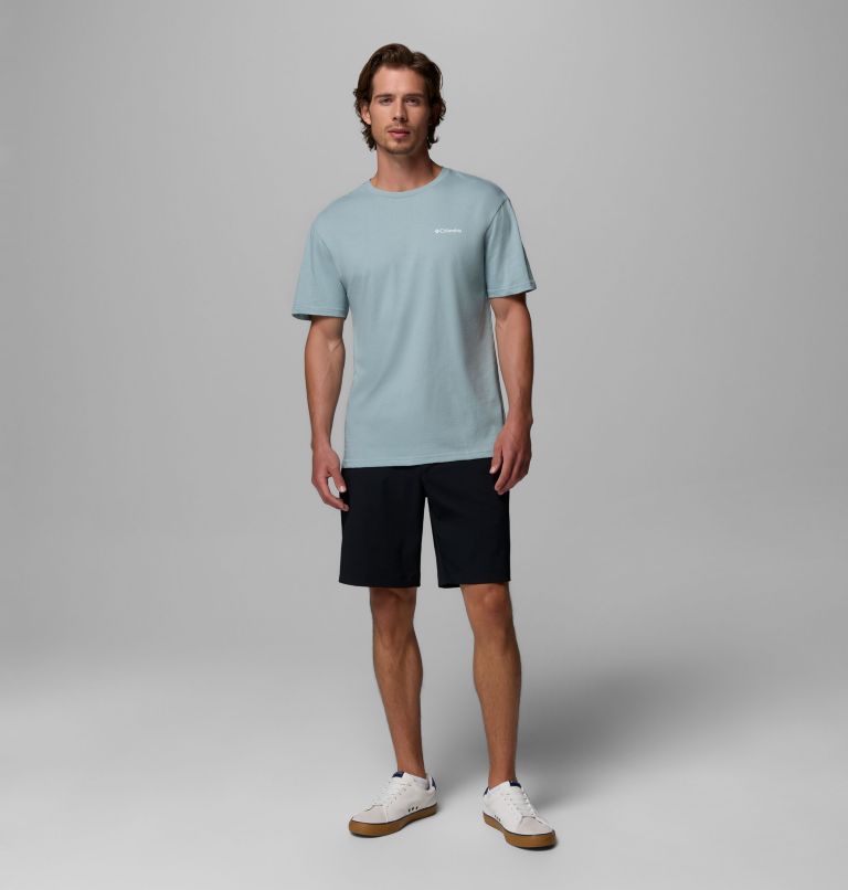 Man wearing a light blue t-shirt and black shorts on a gray background