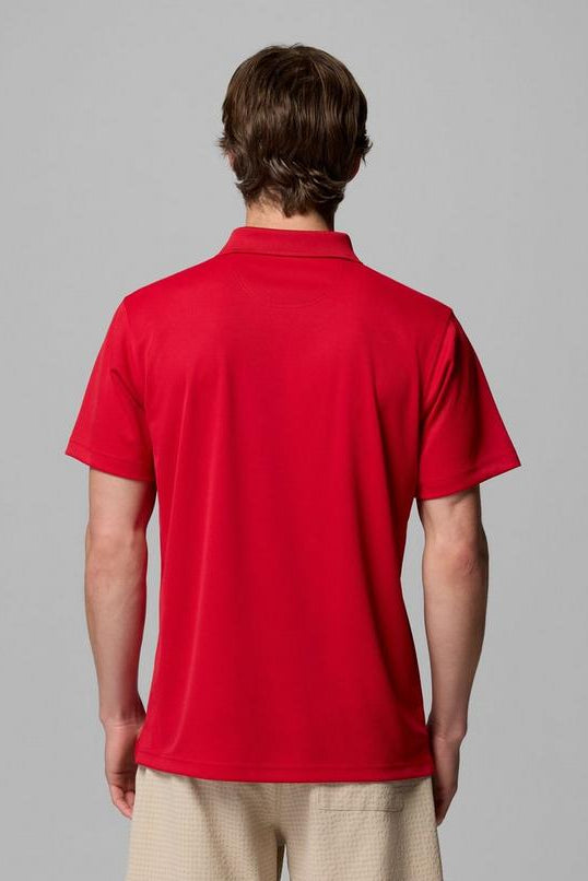 Person wearing a red polo shirt on a gray background