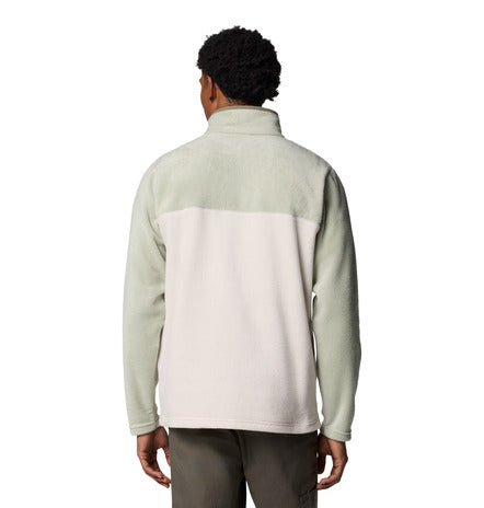 Person wearing a two-tone fleece jacket with green and beige colors on a white background