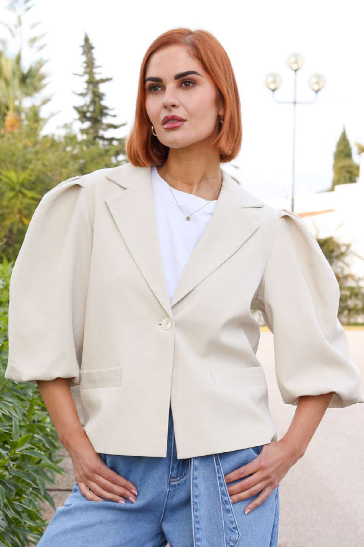 Woman wearing a beige blazer with puffed sleeves outdoors