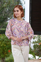 Woman wearing a colorful patterned blouse outdoors