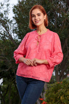 Front view of the Primrose coral top on model