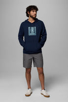 Man wearing a navy hoodie with a graphic design on a gray background