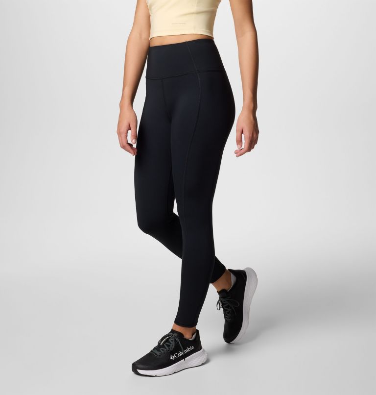 Person wearing black leggings and black sneakers on a light gray background