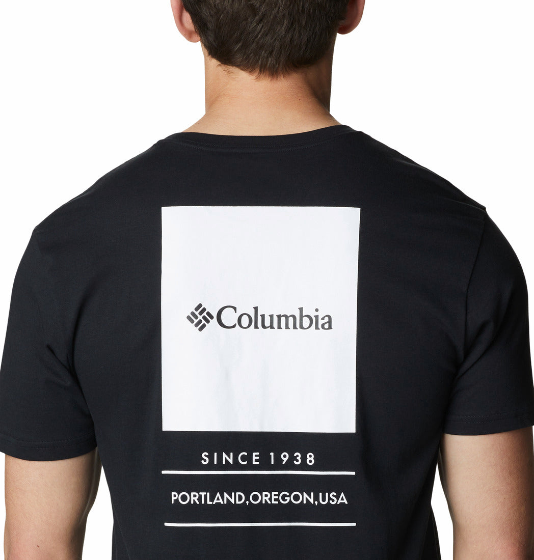 Black t-shirt with Columbia logo and text on the back, worn by a person.