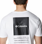 White t-shirt with Columbia logo and text on the back, worn by a person.