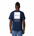 Person wearing a navy blue t-shirt with Columbia logo on the back, standing against a white background