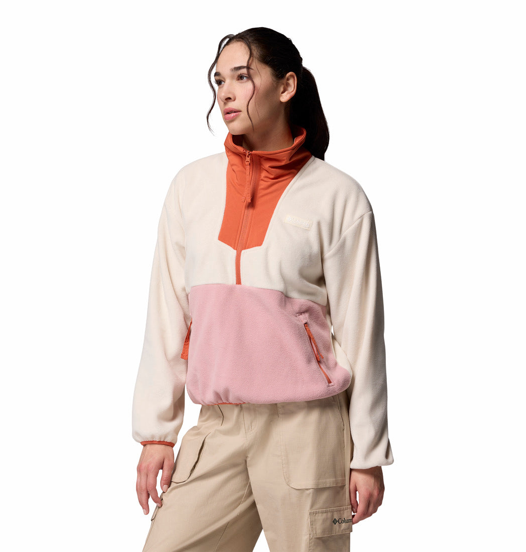 Person wearing a white and pink pullover with beige pants on a white background
