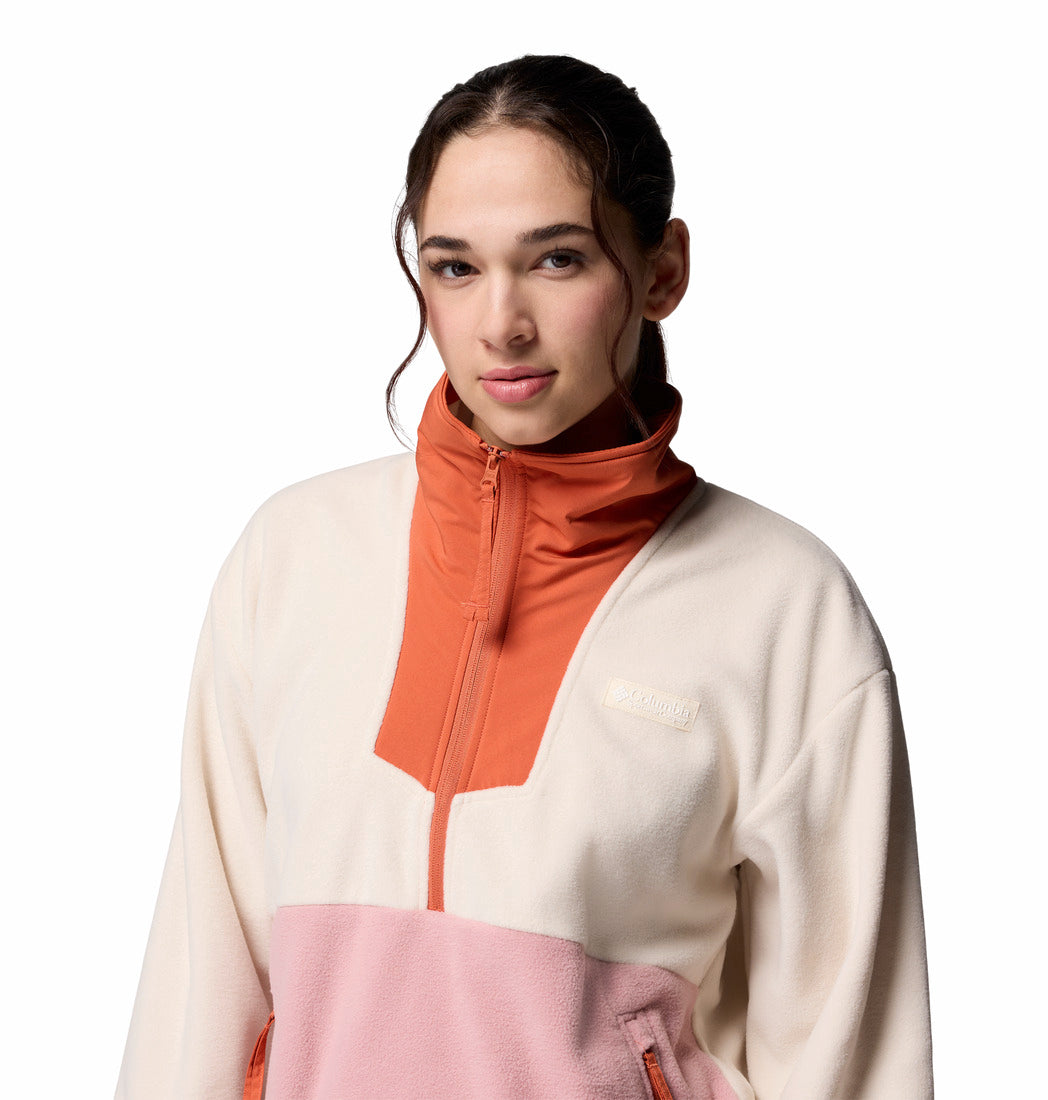 Woman wearing a color-blocked sweater with orange, pink, and white sections on a white background