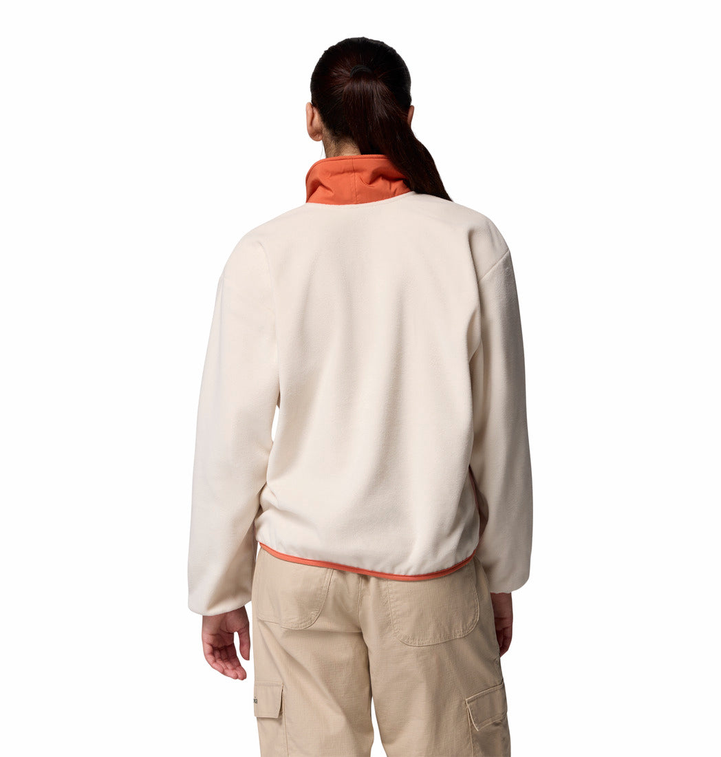 Person wearing a cream-colored fleece jacket and beige pants with a red shirt underneath on a white background