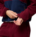 Person wearing a red outfit with their hands clasped together on a white background