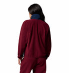 Person wearing a maroon tracksuit on a white background