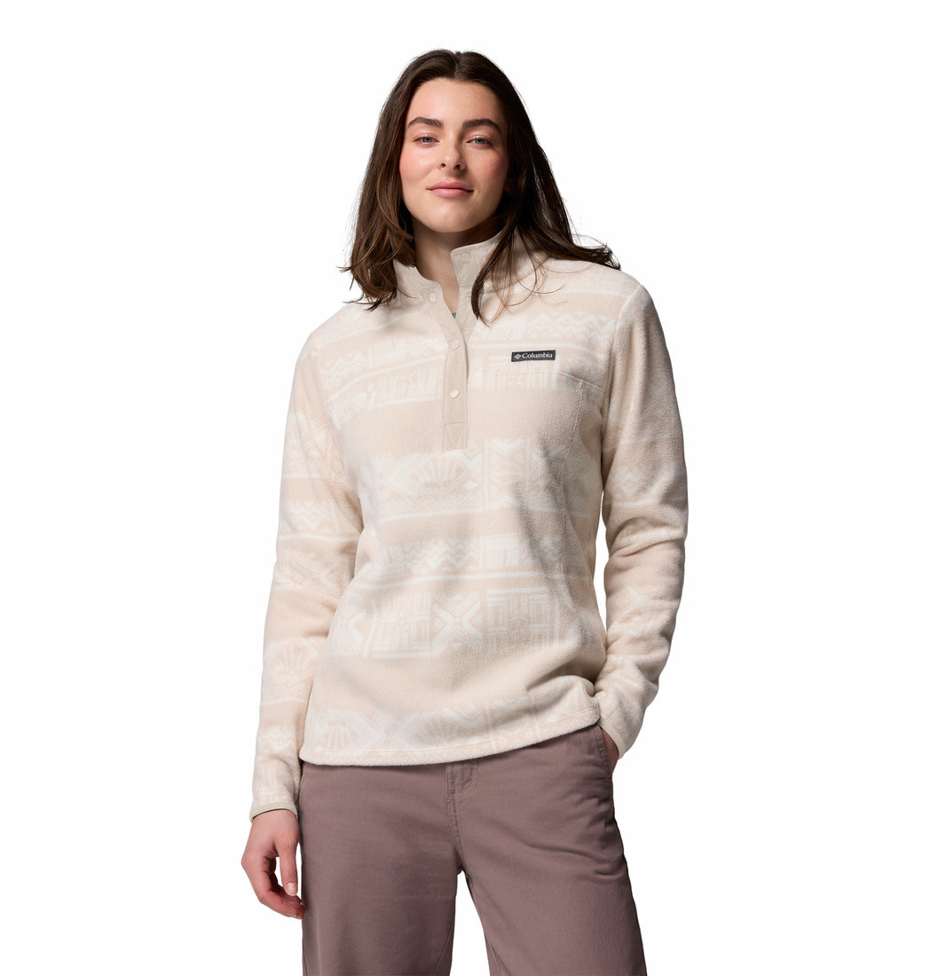 Woman wearing a light-colored pullover with a brand logo on a white background
