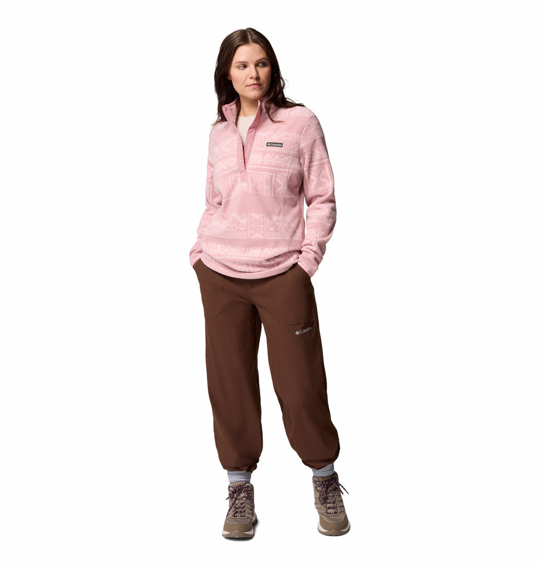 Woman wearing a pink fleece pullover and brown pants on a white background