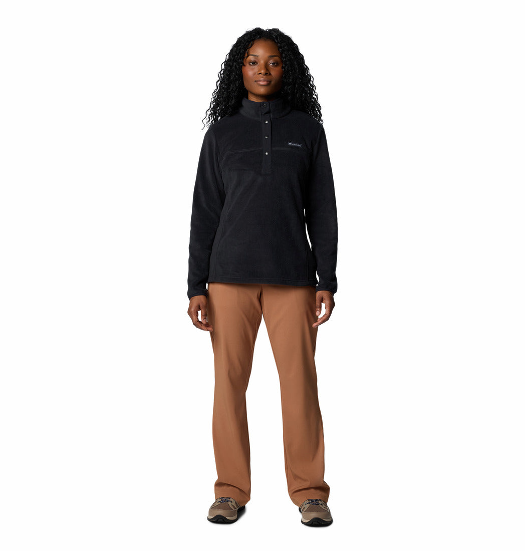 Person wearing a black long-sleeve shirt and brown pants on a white background