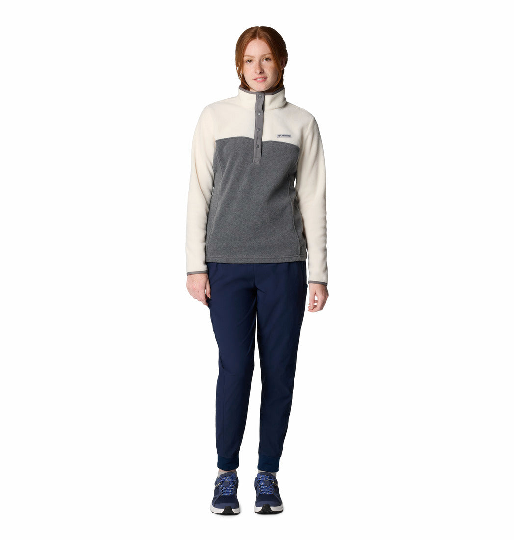 Woman wearing a two-tone pullover and dark pants on a white background