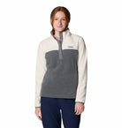 Woman wearing a two-tone fleece pullover with a visible brand logo on a white background
