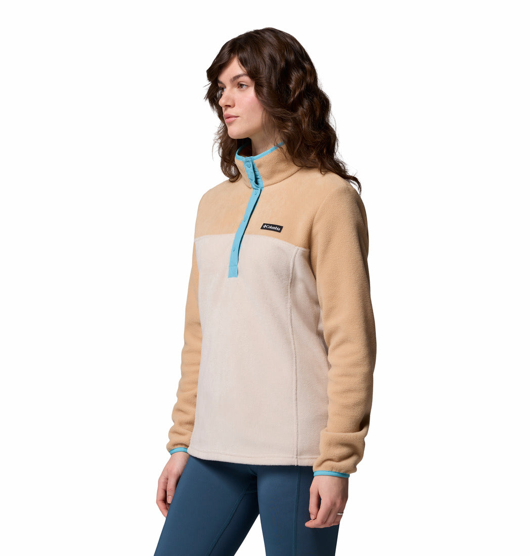 Woman wearing a beige and blue pullover with a visible brand logo on a white background
