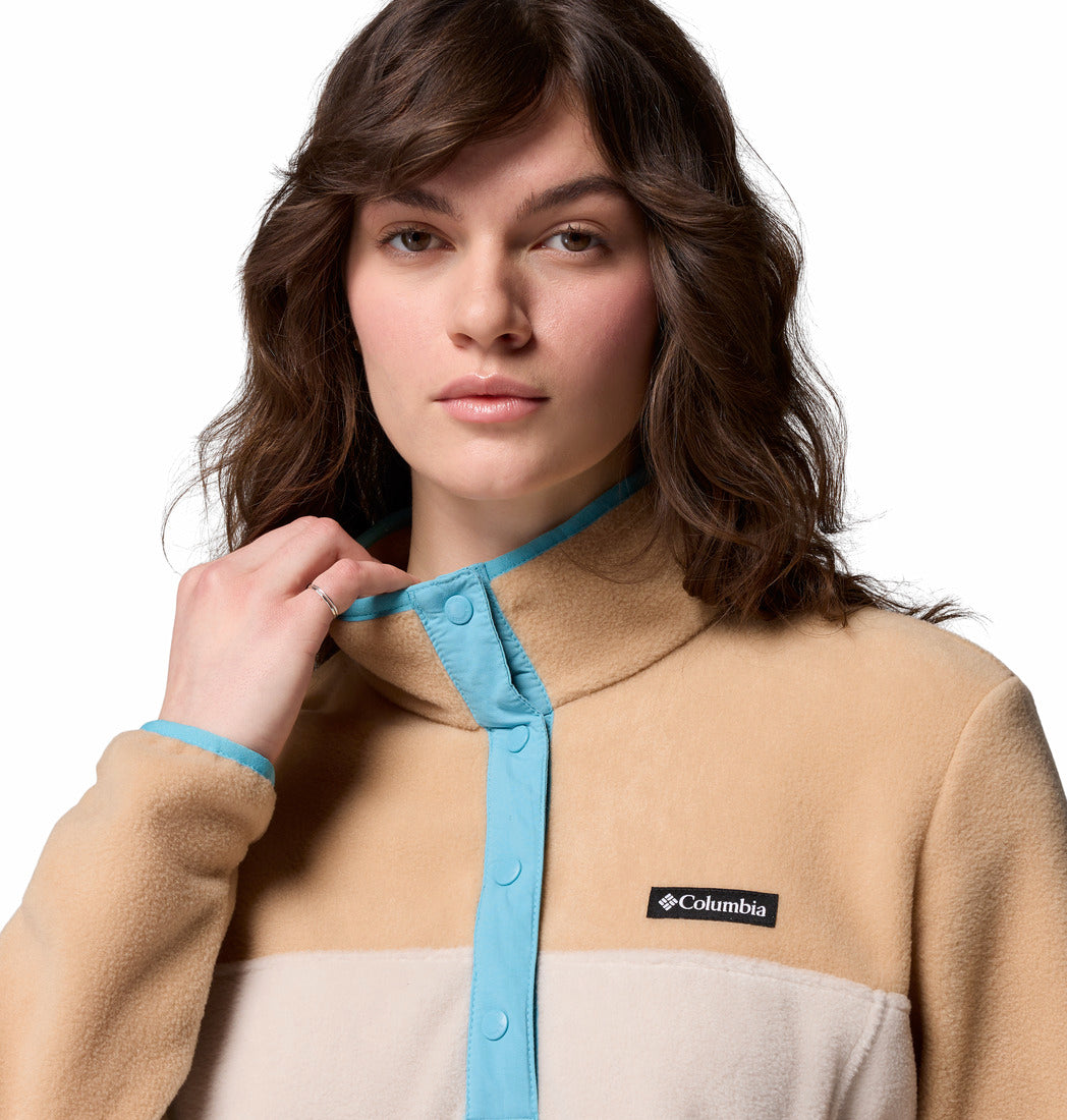 Woman wearing a beige and white Columbia jacket with a blue trim on a white background