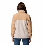 Person wearing a beige and light gray fleece jacket on a white background