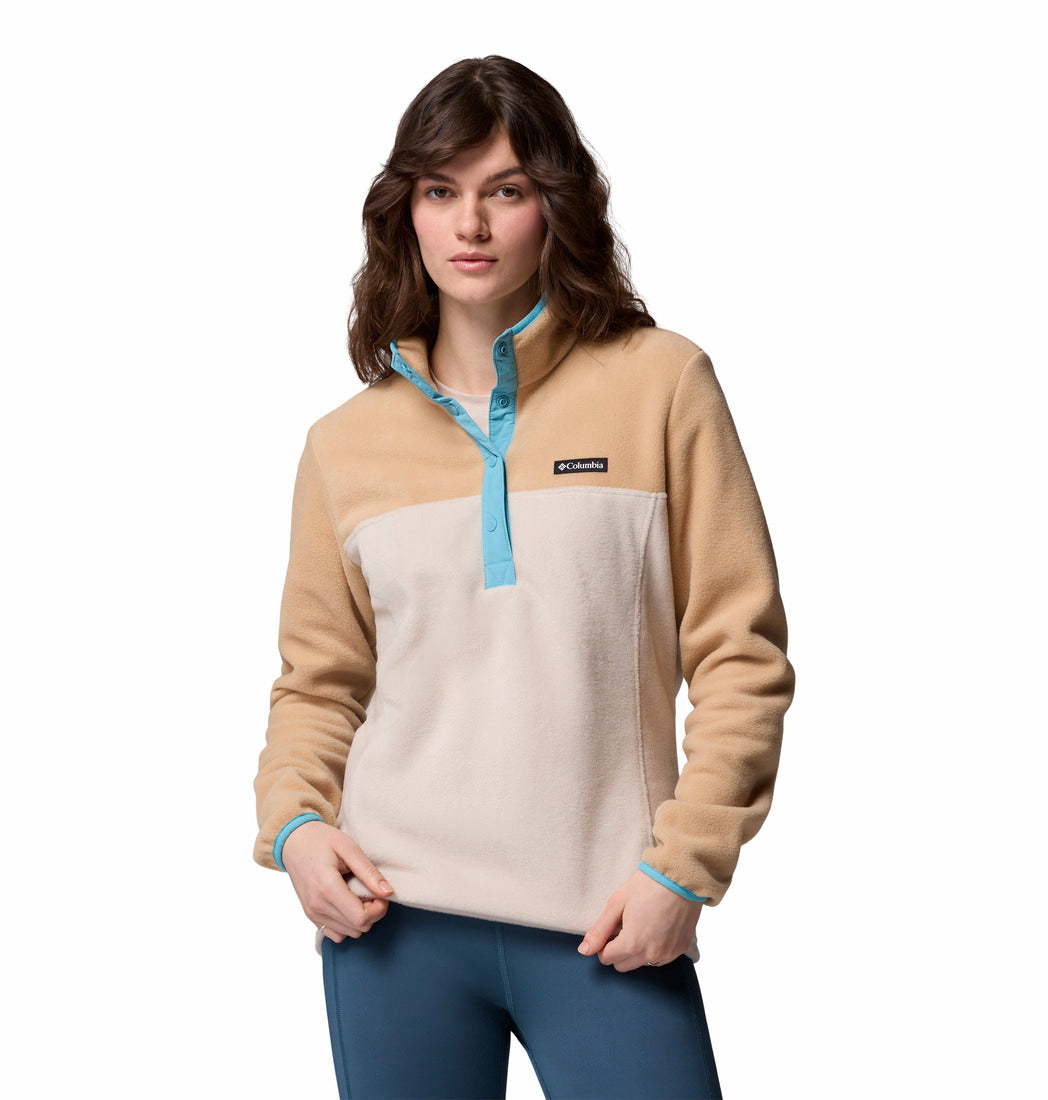 Woman wearing a beige and blue pullover with a visible brand logo on a white background