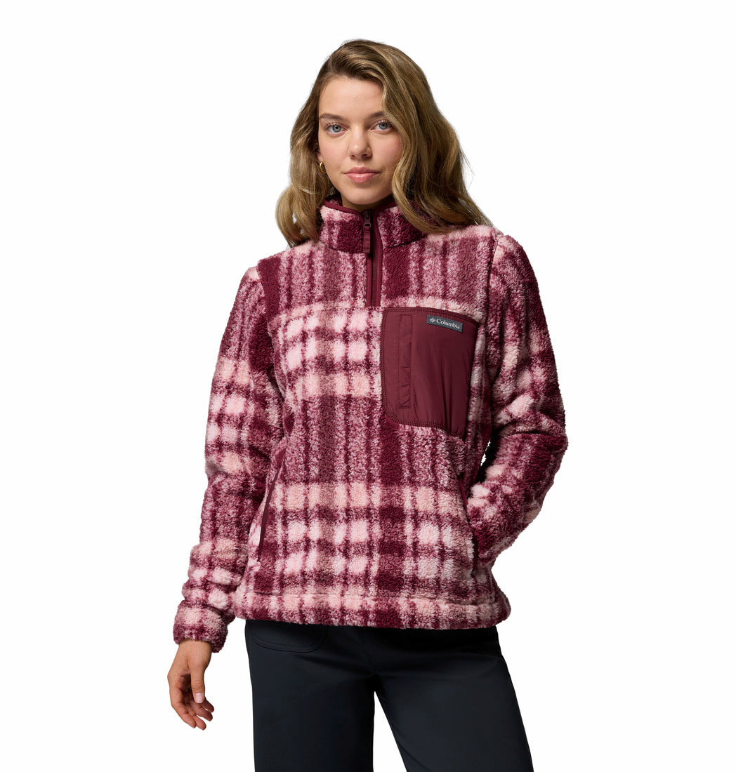 Woman wearing a plaid pullover with a visible brand logo on a white background