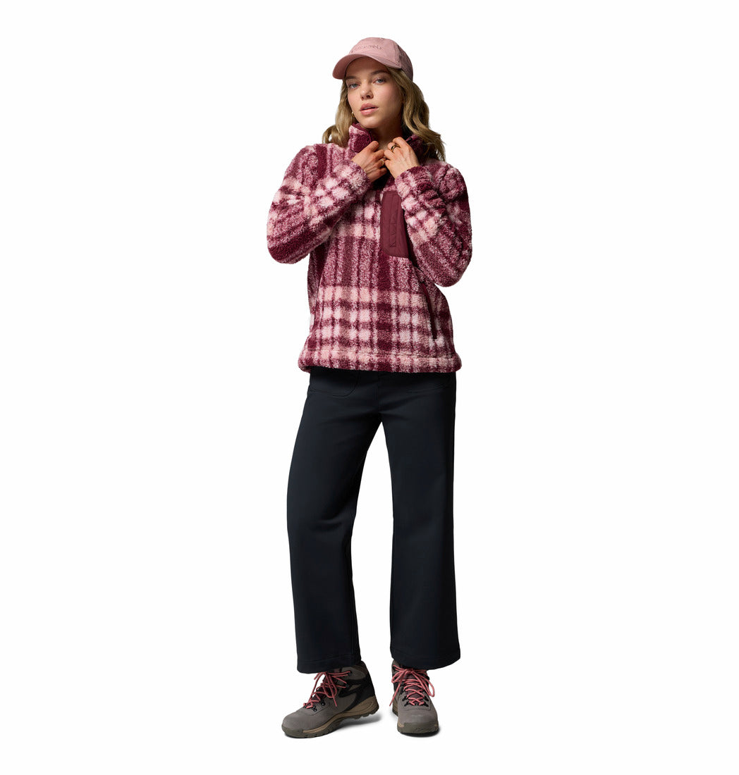 Person wearing a plaid jacket, black pants, and a pink cap on a white background