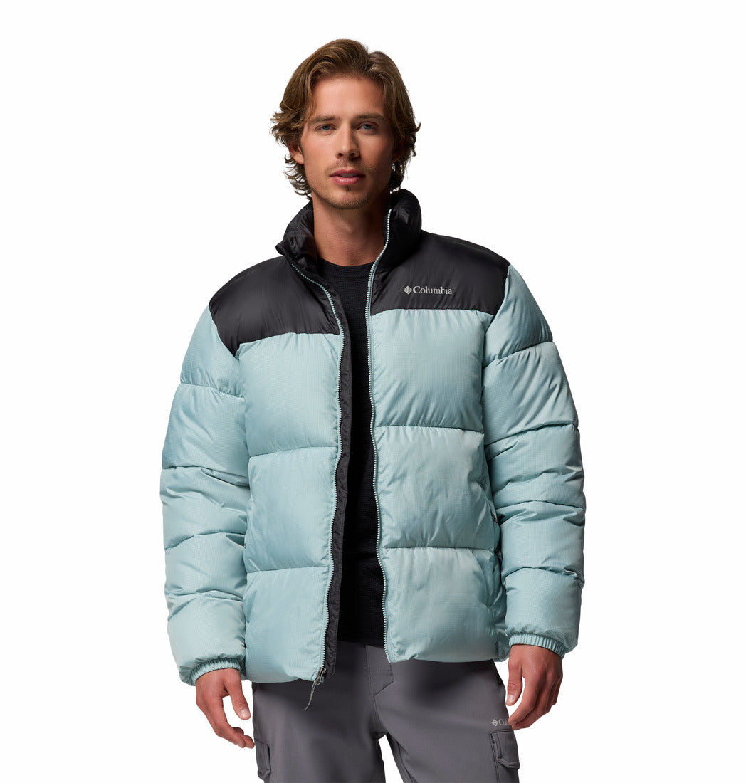 Man wearing a light blue and black puffer jacket on a white background
