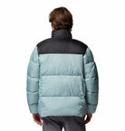 Person wearing a two-tone puffer jacket with a black and light blue design on a white background