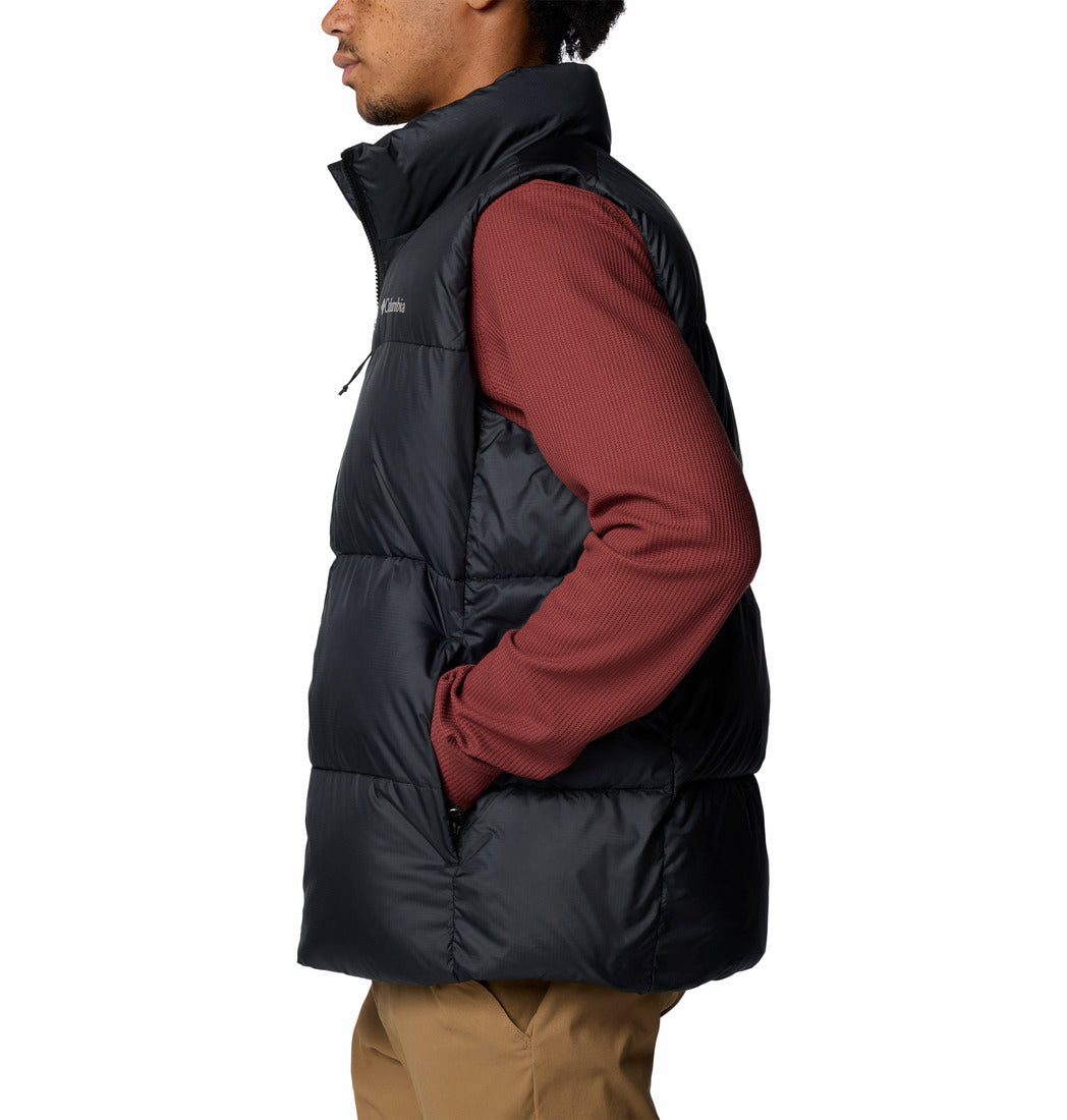 Person wearing a black puffer vest over a red shirt on a white background