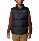 Person wearing a black puffer vest over a red shirt on a white background