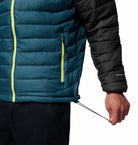 Close-up of a person wearing a teal and black puffer jacket with a visible brand logo.