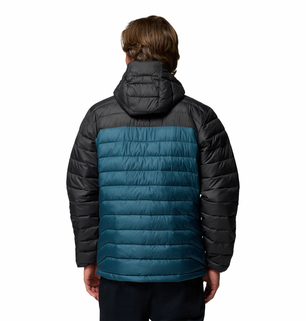 Person wearing a black and teal puffer jacket on a white background