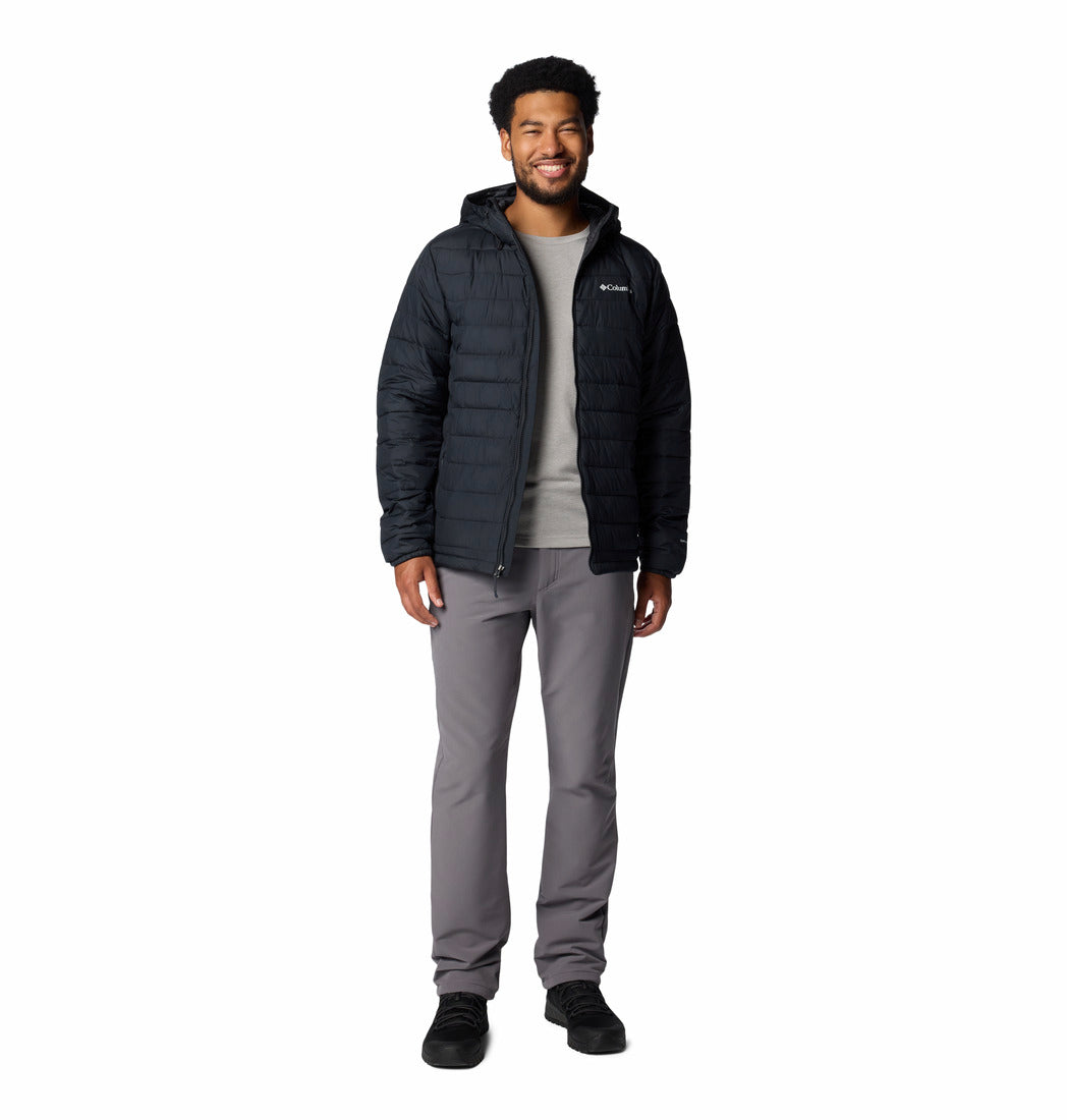 Man wearing a black jacket and gray pants on a white background