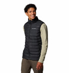 Man wearing a black Columbia puffer vest on a white background