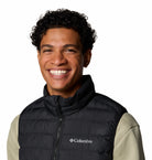 Man wearing a black Columbia vest on a white background