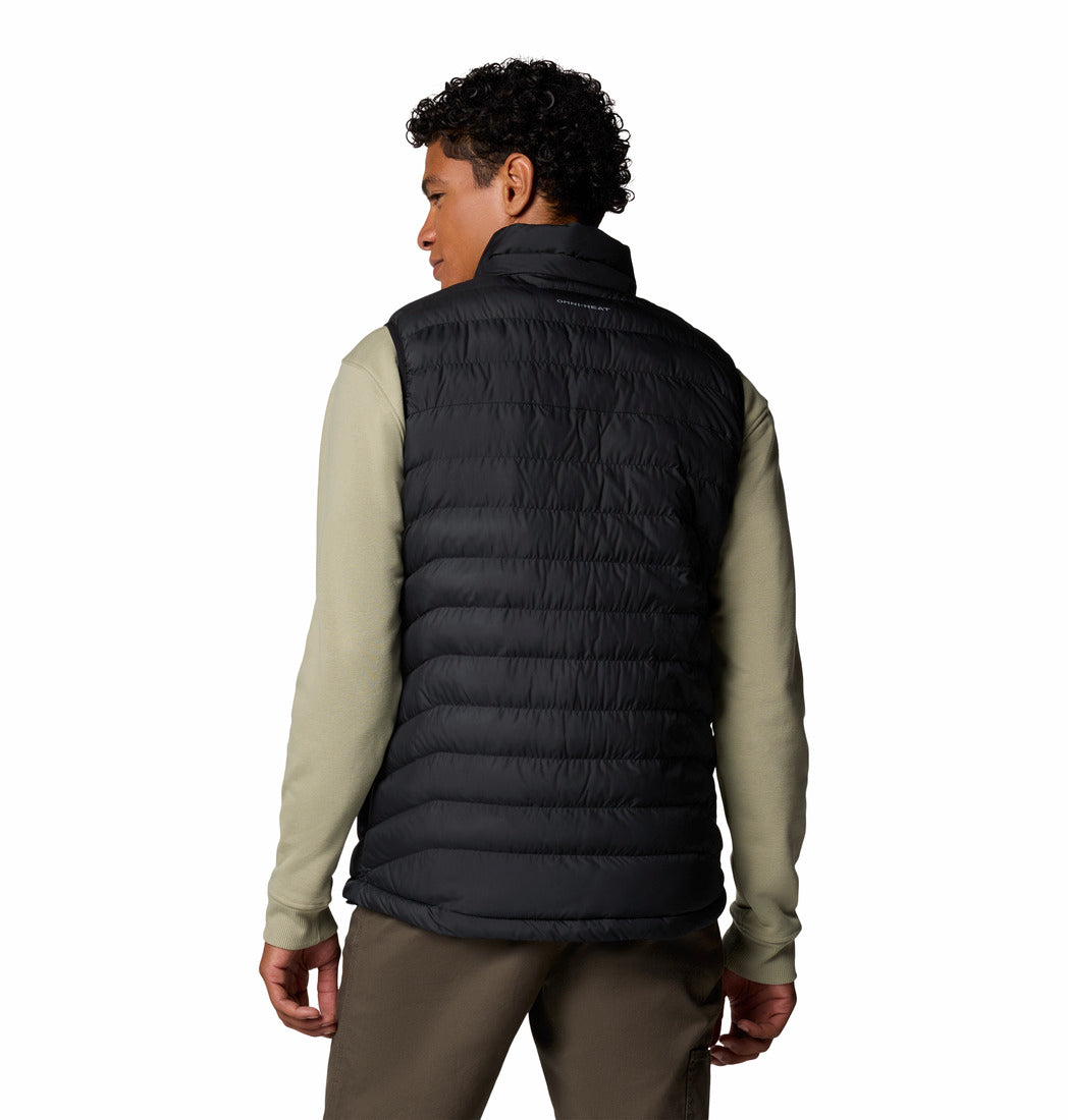 Person wearing a black puffer vest over a light green long-sleeve shirt on a white background