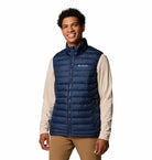 Man wearing a blue Columbia puffer vest on a white background
