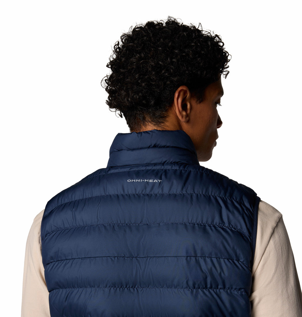 Person wearing a blue puffer vest with a visible brand logo on a white background