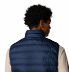 Person wearing a blue puffer vest with a visible brand logo on a white background