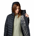 Person wearing a black puffer jacket with reflective lining on a white background