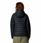 Person wearing a black puffer jacket on a white background