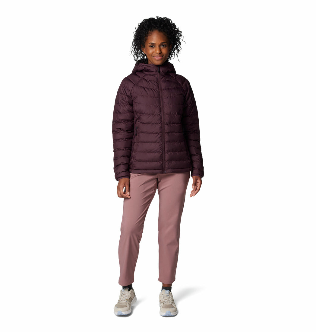 Woman wearing a dark purple jacket and pink pants on a white background