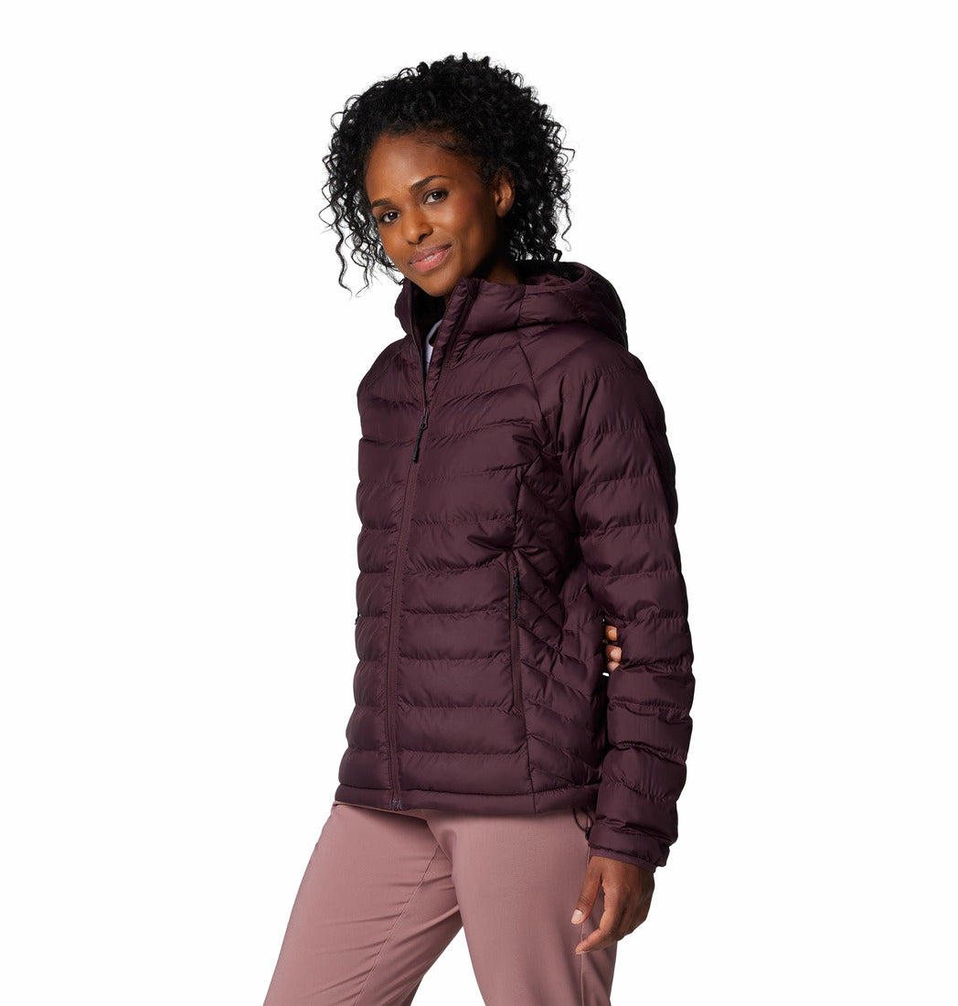 Woman wearing a purple puffer jacket on a white background