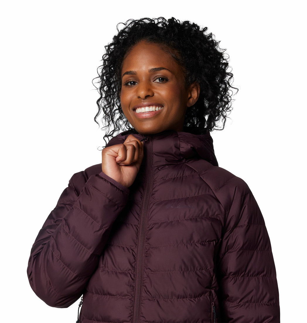Woman wearing a purple puffer jacket on a white background