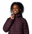 Woman wearing a purple puffer jacket on a white background