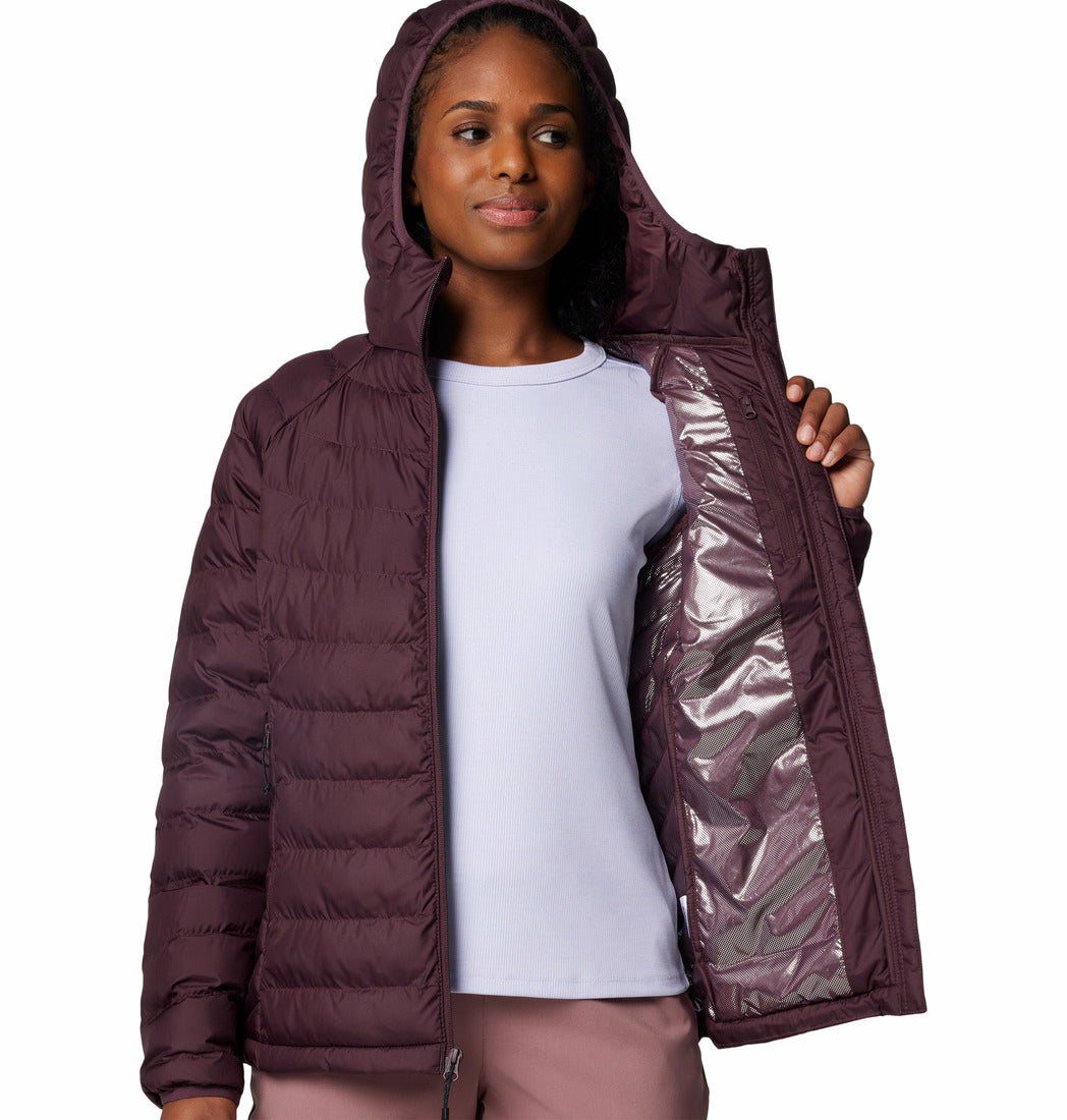 Woman wearing a purple puffer jacket with a white shirt underneath on a white background