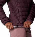 Person wearing a quilted purple jacket with a white background