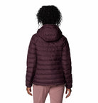 Person wearing a purple puffer jacket on a white background